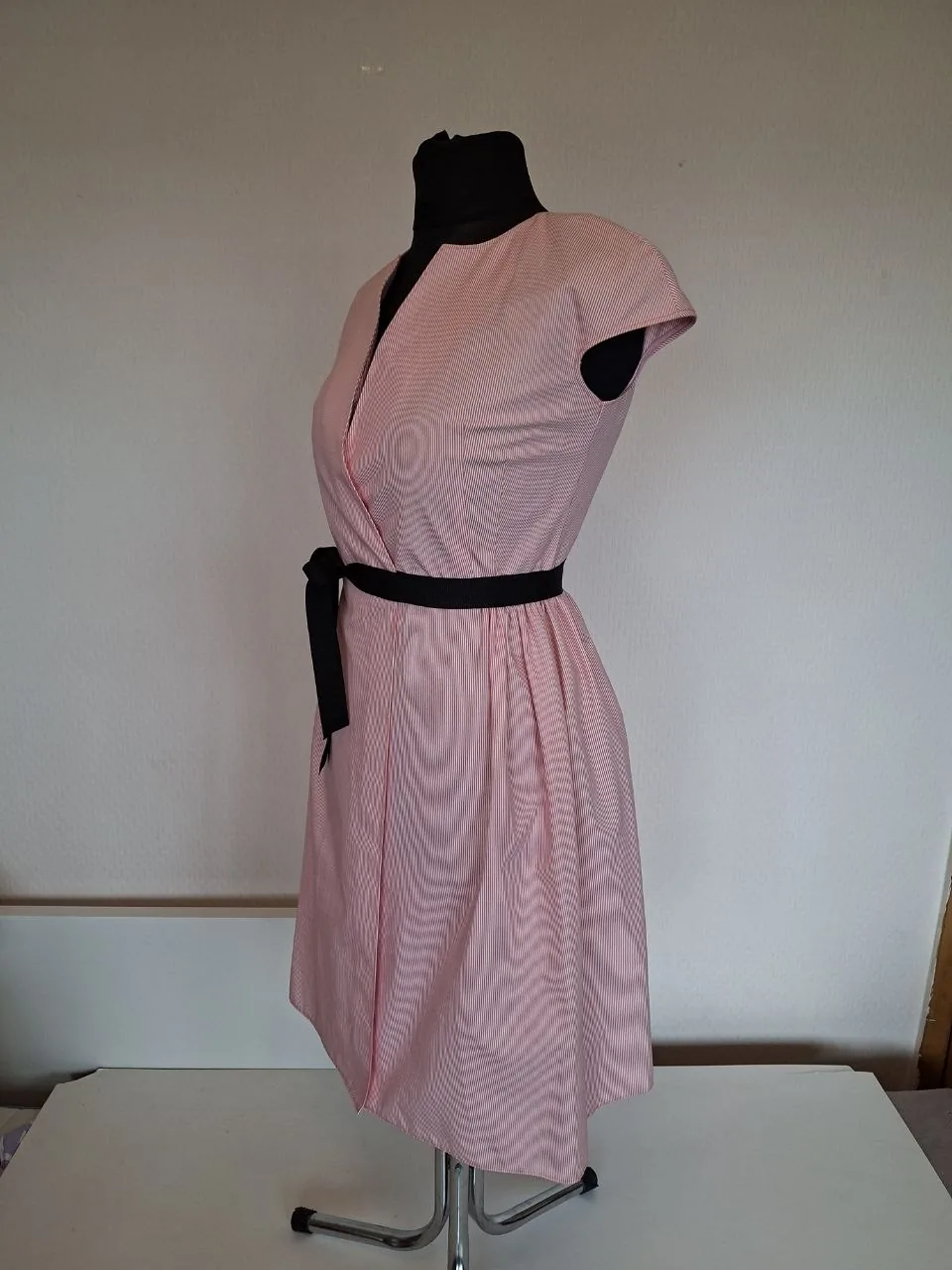 Leinen-Wickelkleid in Größe M, passt auch für Größe S. Dieses Kleid ist knielang mit einer Wickelfront und einem V-Ausschnitt, kurzen Ärmeln, einem schwarzen Bandgürtel an der Taille und einem leicht ausgestellten Rockteil, gefertigt aus…